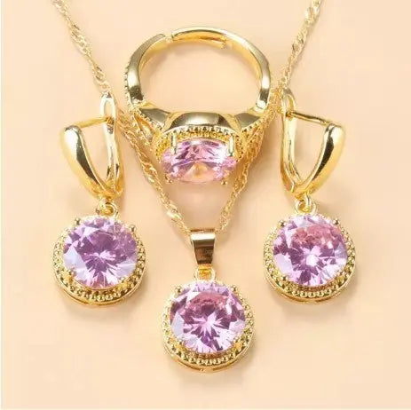 Set de bijoux Ramiart doré avec pierres lilas brillantes. Collier, bague et boucles d’oreilles assortis pour un style féminin et raffiné.