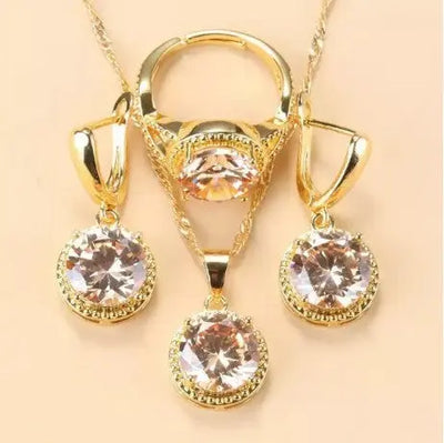 Set de bijoux Ramiart doré avec pierres champagne étincelantes sur collier, bague et boucles d’oreilles. Élégance raffinée pour tenues habillées.