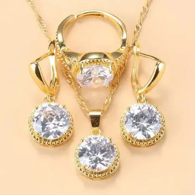 Parure de bijoux Ramiart avec boucles d’oreilles, bague et collier dorés ornés de pierres blanches scintillantes. Idéal pour femmes élégantes.